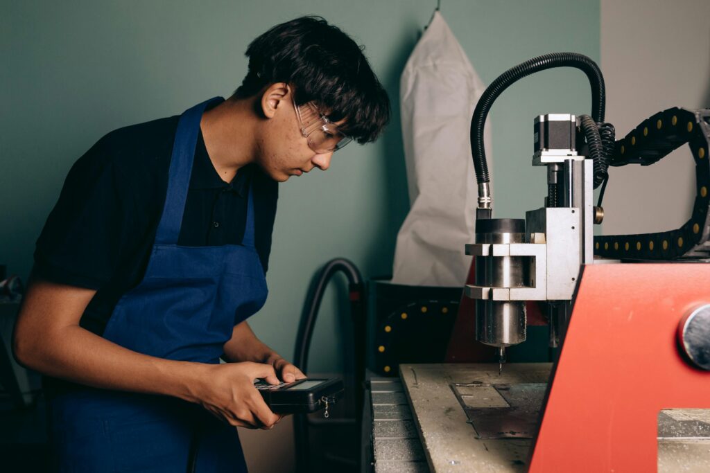 Man in Apron by Table with Industrial Machine